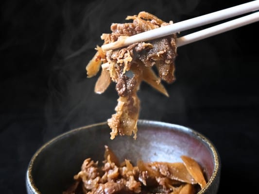 博多久松おせち「博多」参の重の食材㊳牛肉牛蒡しぐれ煮を温めた後の状態。細かくカットされた牛肉とごぼうから湯気がでている。