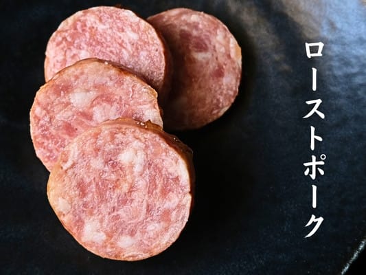 博多久松おせち「博多」弐の重の食材⑳ローストポークが4枚皿の上に並んでいる。サラミのような見た目。