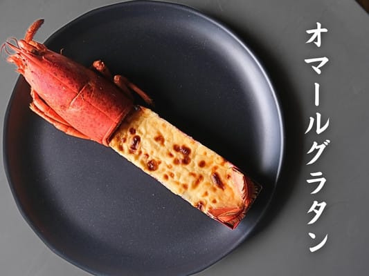 博多久松のおせち「博多」の壱の重の食材①オマールグラタンを上から撮影。オマール海老の頭、胴体部分にはグラタンが入った容器がついています。