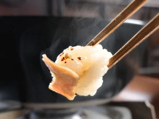 もつ鍋の主役、持つを箸でつまむ。