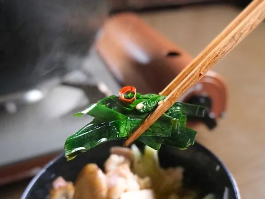 輪唐辛子がついた、クタクタになりおいしそうなニラ。