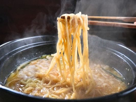 鍋の中から麺を箸でつまんで硬さを確認。