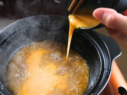 鍋にご飯を入れて、溶き卵をまわしいれる。
