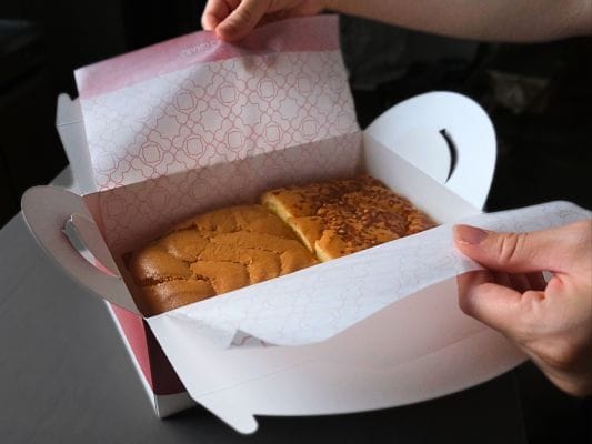 カステラをそのまま持つのではなく、包み紙の両端をもてばお皿に移動しやすい。