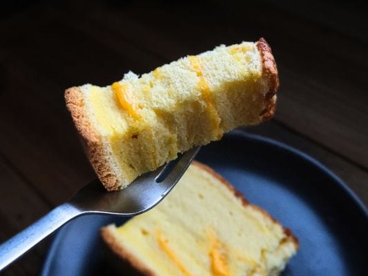 ひと口サイズにカットしたチーズをフォークにのせる。
生地の間からチーズがはみだしてるところもある。