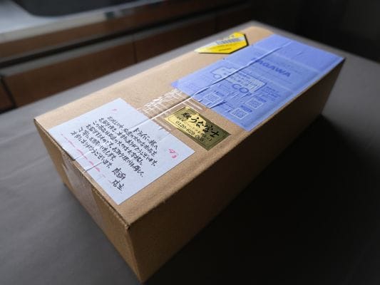 茶色の段ボール箱。
箱にはうな富士とかかれた金色のシールと、運送会社のドライバーあての注意書き＆感謝の言葉が記載されている。
