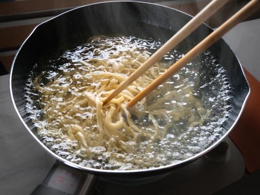 菜箸でやさしく麺をほぐしている。