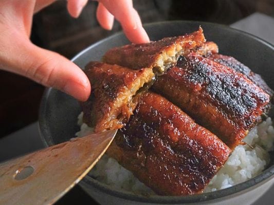 うな富士の青うなぎをカットしてうな丼に盛り付けている