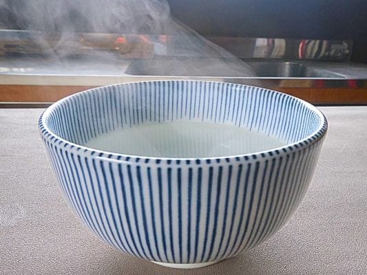 つけ汁用の丼にあつあつのお湯を入れている