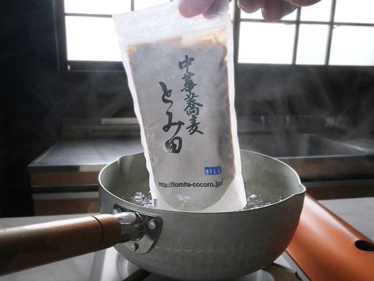 雪平鍋にスープを袋ごと入れている