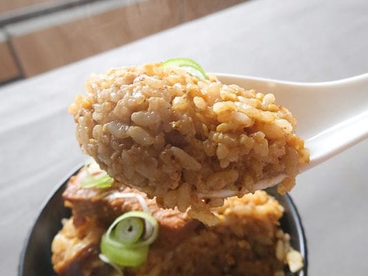 魚介と柚子の香りが広がるおじやをレンゲですくい上げたところ