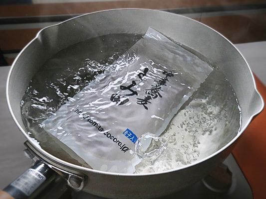 グツグツと沸騰しているお湯の中でたたずむスープの袋