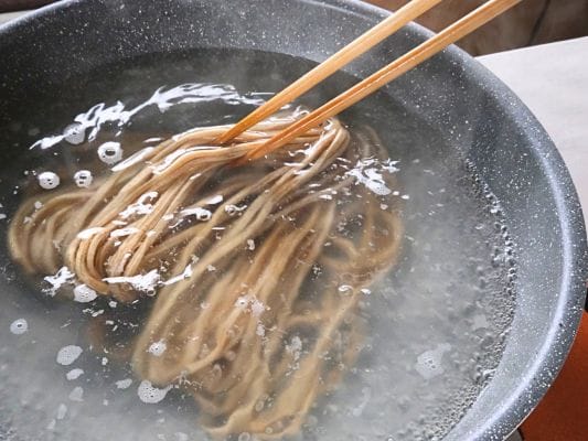 折れないようにやさしく箸で冷凍麺をほぐしているところ