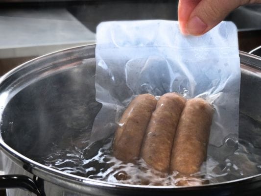 沸騰したお湯の中にスパイスを袋のまま入れている。