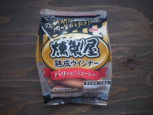 丸大食品の燻製屋熟成あらびきポークウインナーのパッケージ。