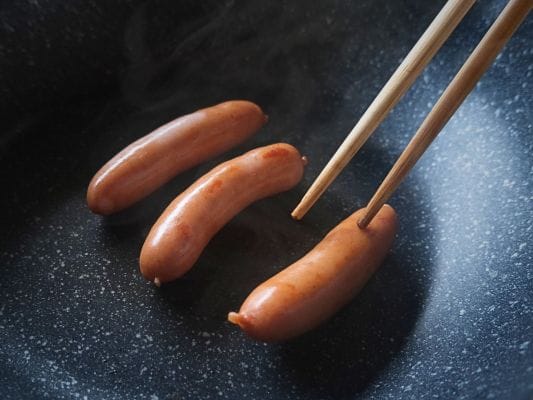 丸大食品の燻製屋熟成あらびきポークウインナーをフライパンで炒めている