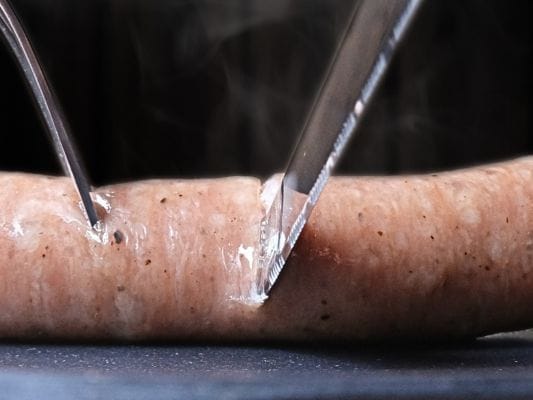 黒豚をナイフでカットしている。断面から肉汁が溢れ出てくる。