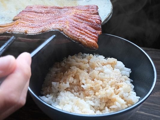 湯煎したうなぎ処 古賀の蒲焼「竹」をご飯の上にのせている