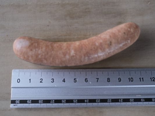 黒豚の長さを定規で測っている様子。長さは約11.5cm。