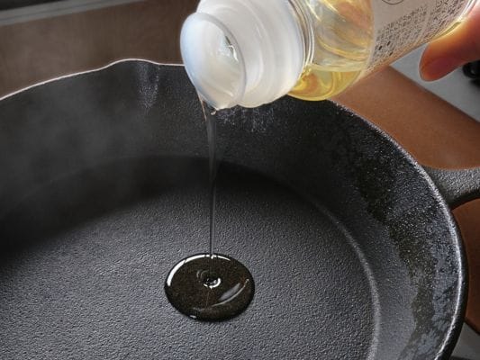 吟醸粕漬けを焼く前に、フライパンへ少量の油を入れている。