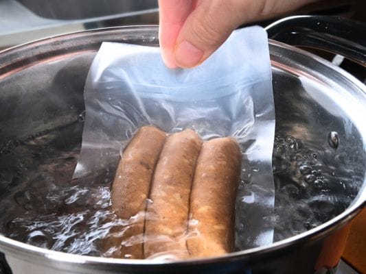 沸騰したお湯の中にあらびきを袋のまま入れている。