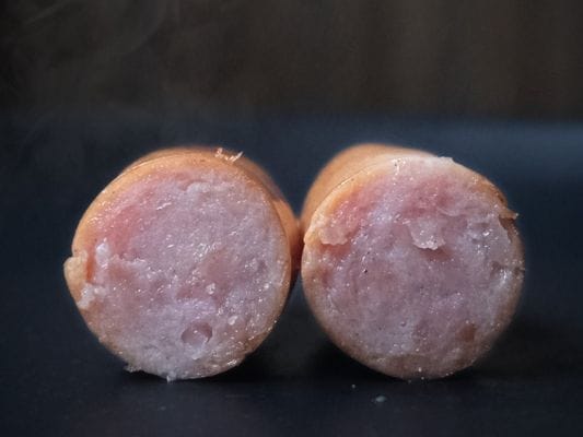 丸大食品の燻製屋熟成あらびきポークウインナーの断面図。