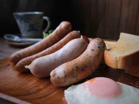 FOR365のソーセージとトースト、目玉焼きを盛り付けた朝食プレート。湯気が立っている。