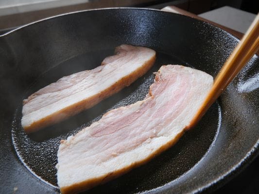 カットした厚さ約7mmのベーコンをフライパンに置いた状態。