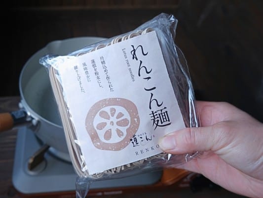れんこん麺のパッケージを手に持っている
