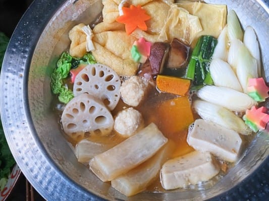野菜・生麩・湯葉・餅入り巾着・鶏団子を鍋で煮込んでいる