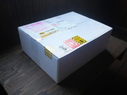 滋味六感のしゃぶしゃぶ食べ比べセットが入った白い外箱。ヤマト運輸の伝票やナマモノシール、天地無用シールなどが貼られている