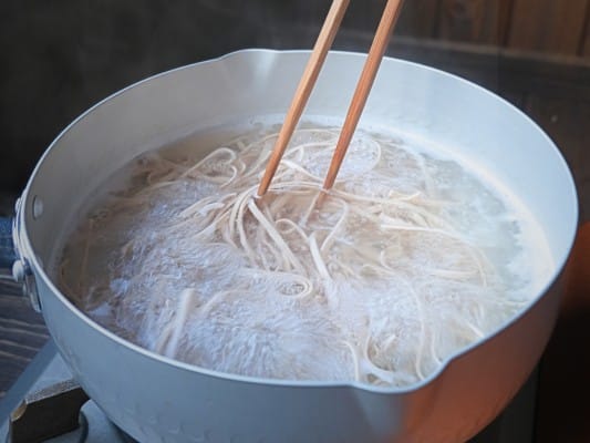 沸騰したお湯でれんこん麺をゆでている