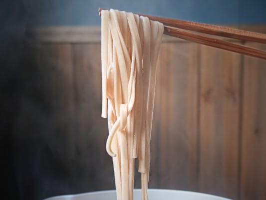 茹で上がったれんこん麺を箸で持ち上げている