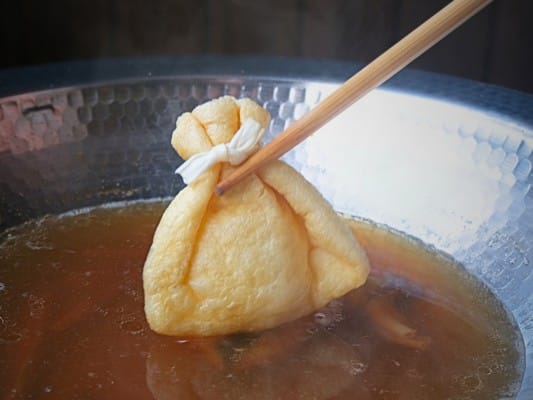 餅入り巾着を鍋に入れるところ