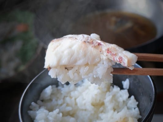 しゃぶしゃぶした真鯛をご飯にのせ、箸で持ち上げている