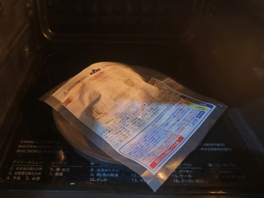 ガスト チーズINハンバーグを袋のまま皿に乗せてレンジに入れている