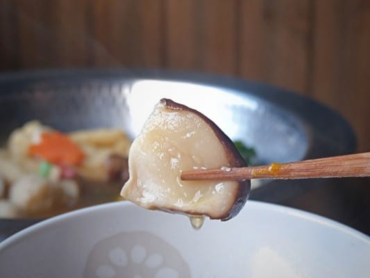 鍋で煮込んだしいたけ。しいたけからは湯気が立ち、だしが滴り落ちている
