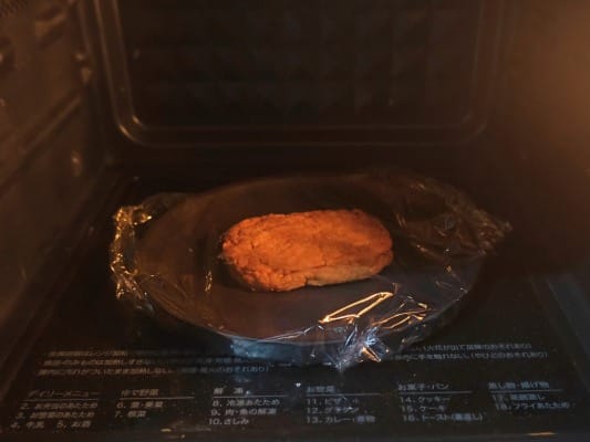 マルシンハンバーグをレンジに入れて温めている