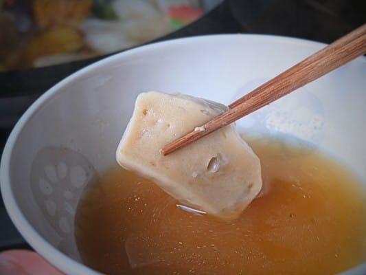 鍋で温めた京都老舗の生麩（蓮根麩）を箸で持ち上げている