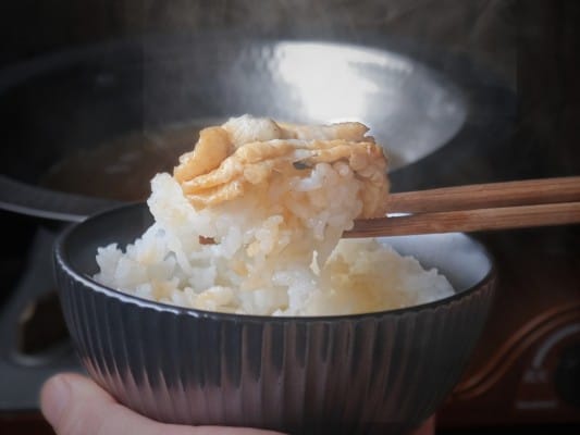 わさび醤油につけたうなしゃぶをご飯にのせ、箸で持ち上げている