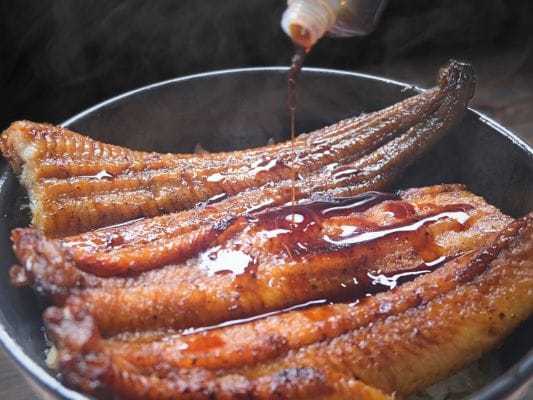 うな丼にしたうなぎ四代目 菊川「一本うなぎ」に付属のたれをかけている