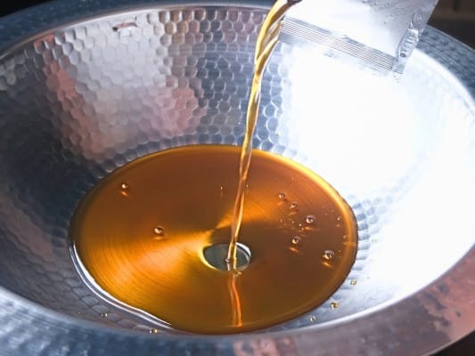 滋味六感 蓮こんの特製だしを袋から鍋に注いでいる