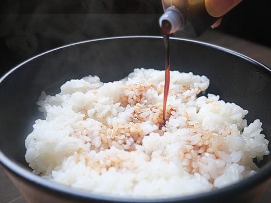 熱い白米に、うなぎ四代目 菊川「一本うなぎ」に付属のたれをかけている