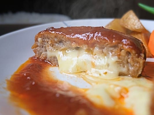 ガスト チーズINハンバーグの断面からチーズがとろけて垂れている