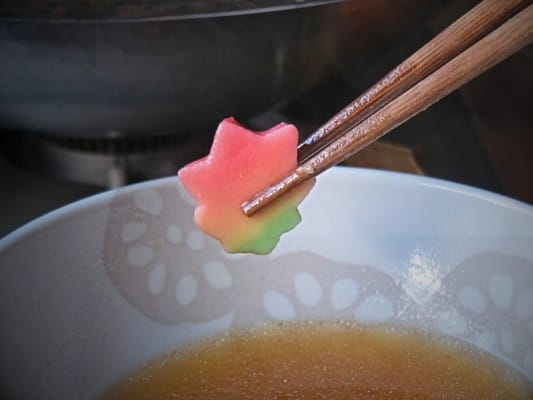 鍋で煮込んだ花麩を箸で持ち上げている