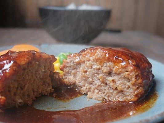 セブンプレミアム ゴールド 金のハンバーグの断面。肉厚なハンバーグに濃厚なソースがからんでいる