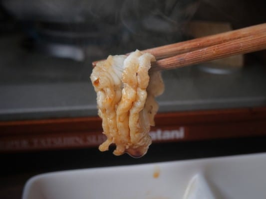 しゃぶしゃぶしたうなぎをわさび醤油につけたため、身の半分が白から茶色に変化している