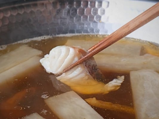 鍋のだしに真鯛をくぐらせてしゃぶしゃぶしている
