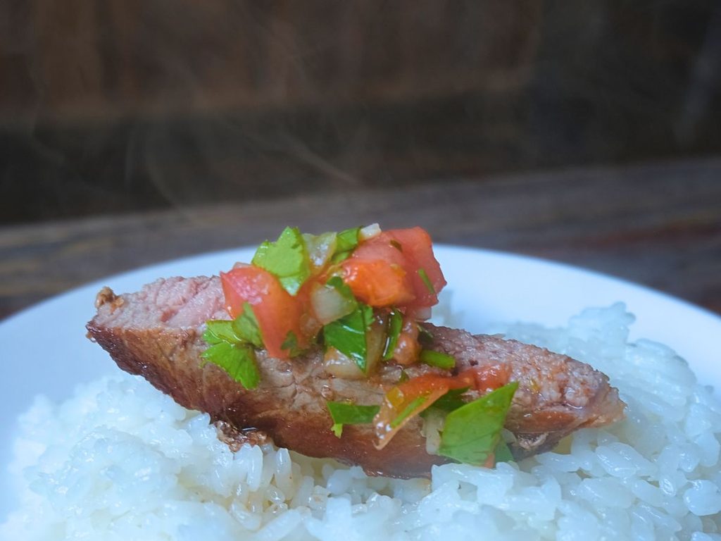 チミチュリソースをのせたアルゼンチン産牛肉リブロースとご飯
