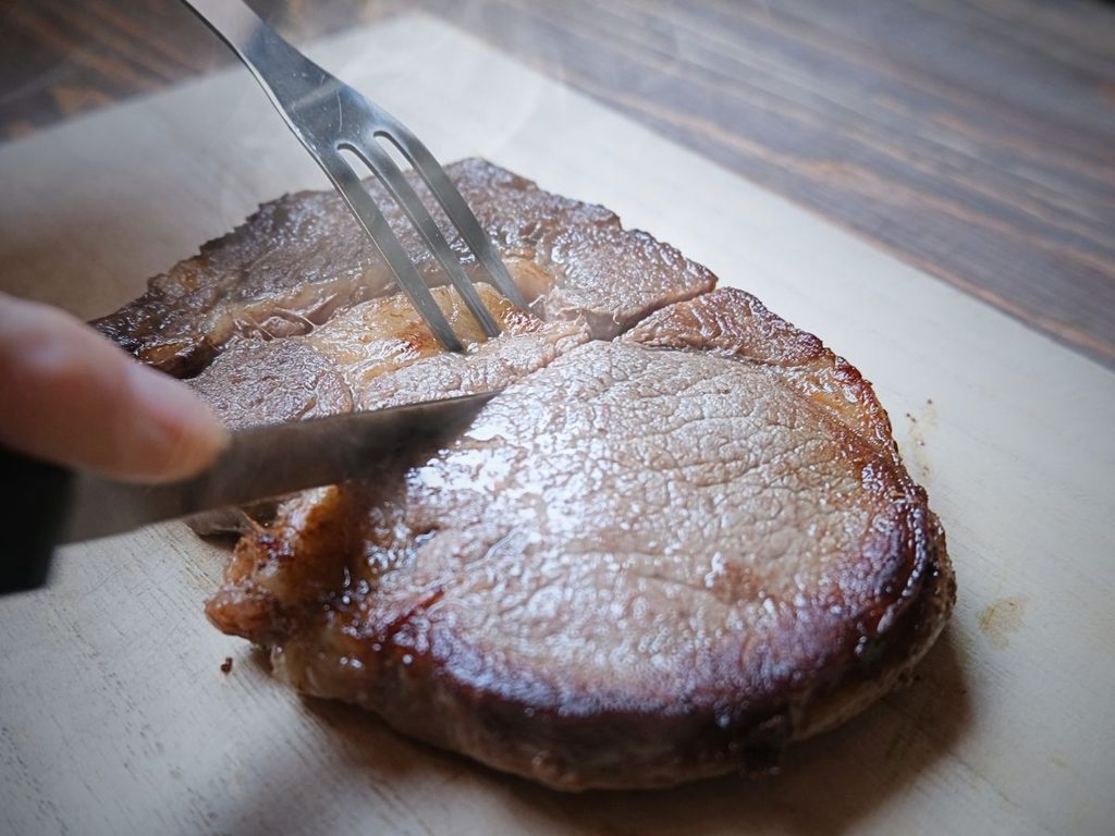 焼き上がったアルゼンチン産牛肉リブロースをナイフでカットする様子